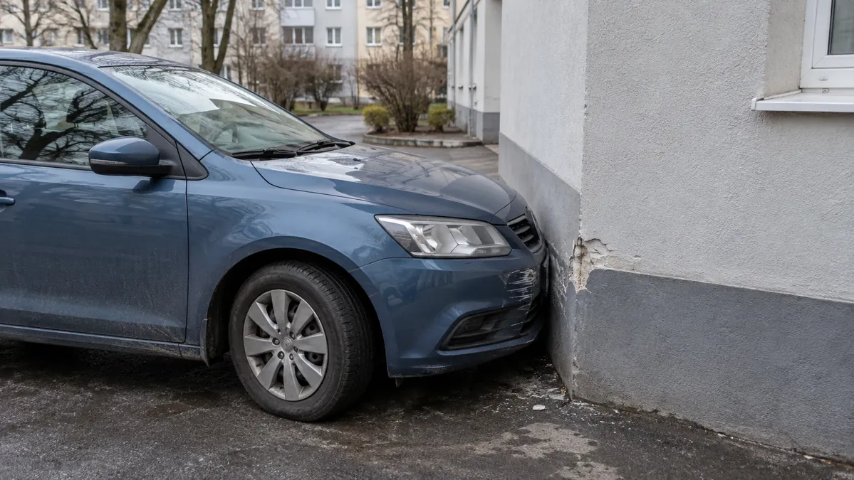 Автомобиль остановился у слегка повреждённого угла здания